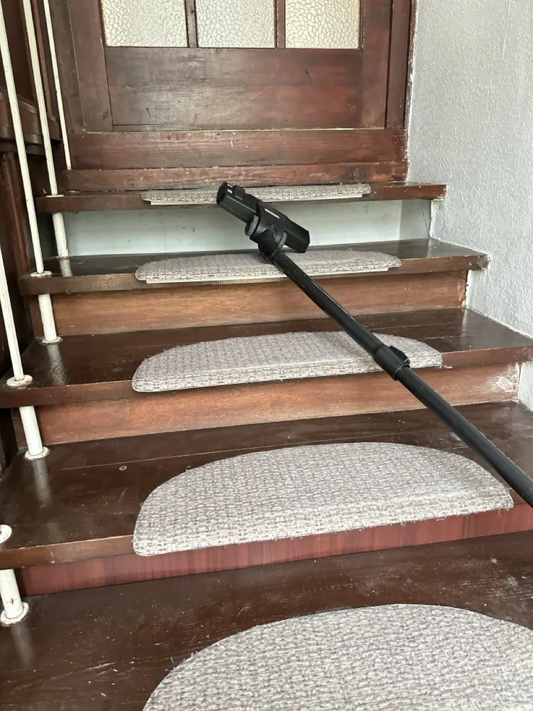 A CLB cleaner vacuuming the stair mats in a Budapest house