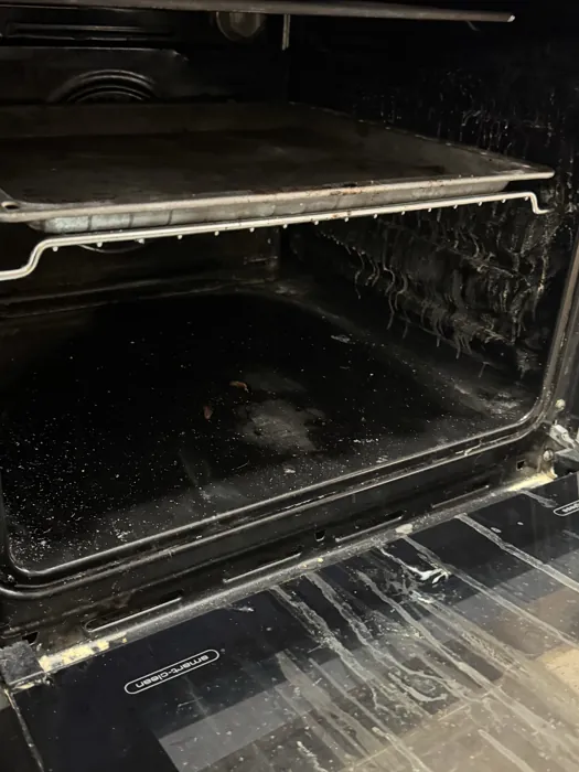 Oven interior before cleaning, carbon build-up across the base and the door seal