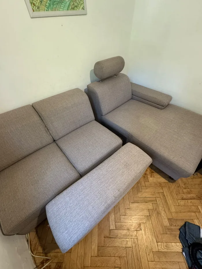 The same corner sofa after hot-water extraction, one seat cushion stood on end to dry